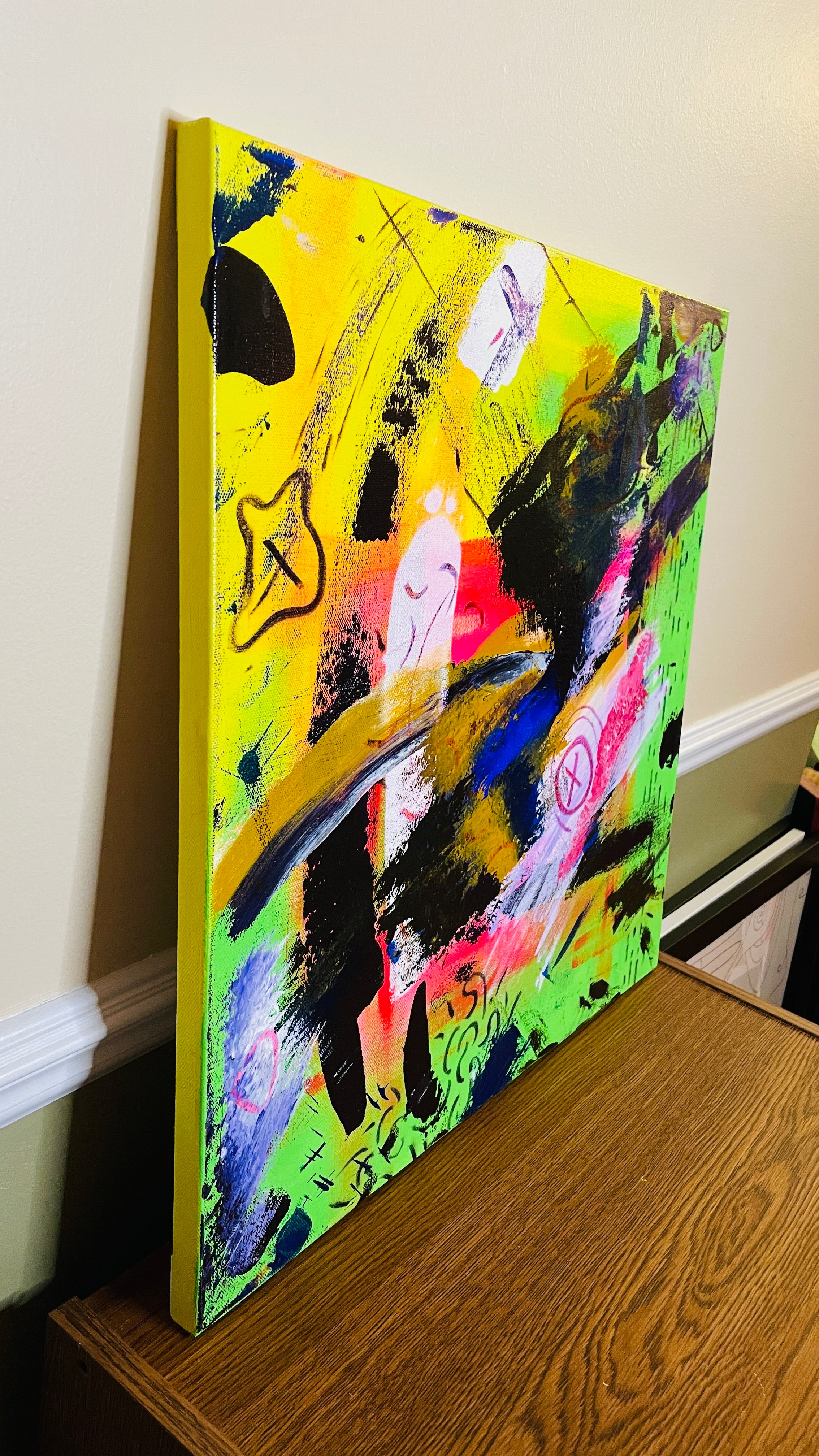 Square abstract mixed-media painting with neon yellow and green fields, sweeping black strokes, pink, blue, gold and white layers, pale simplified figures, crossed-out symbols, drawn lines and heavily textured passages.